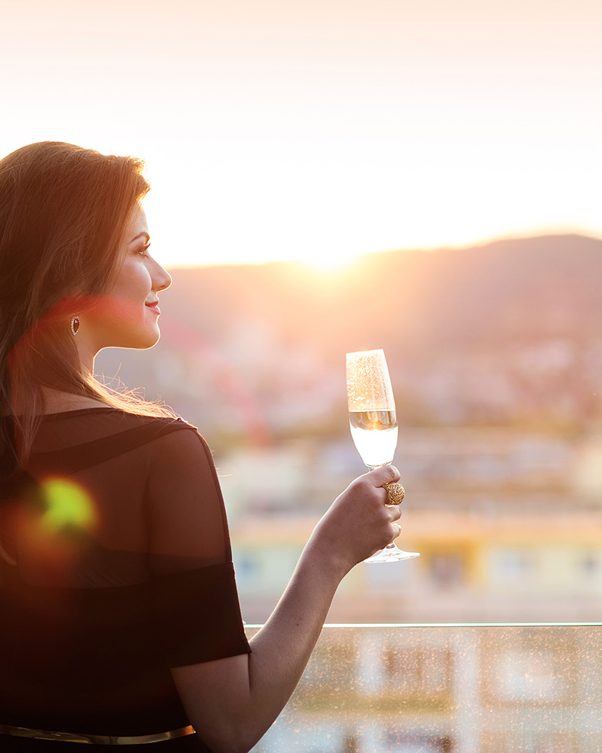 Attractive young woman with a drink on a terrace of a bar